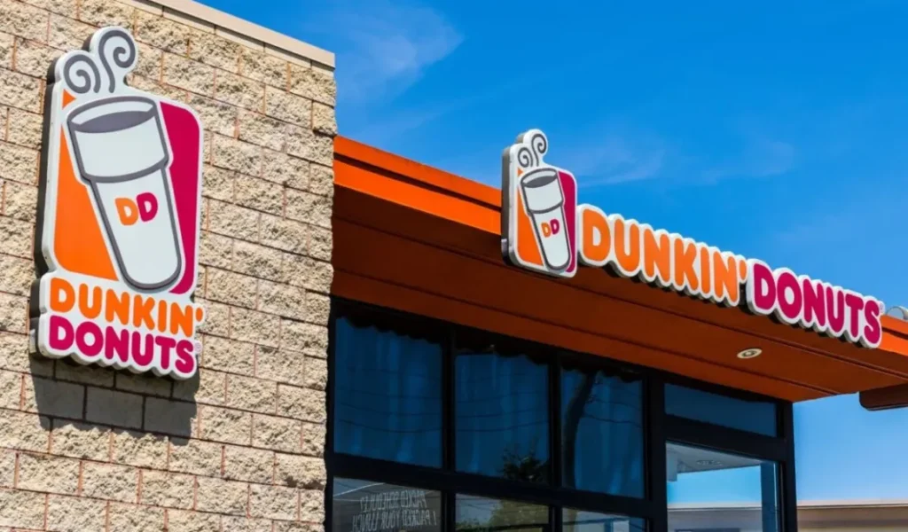 A Dunkin' Donuts storefront with the iconic orange and pink logo featuring a coffee cup. Dunkin Donuts Coffee Menu With Prices