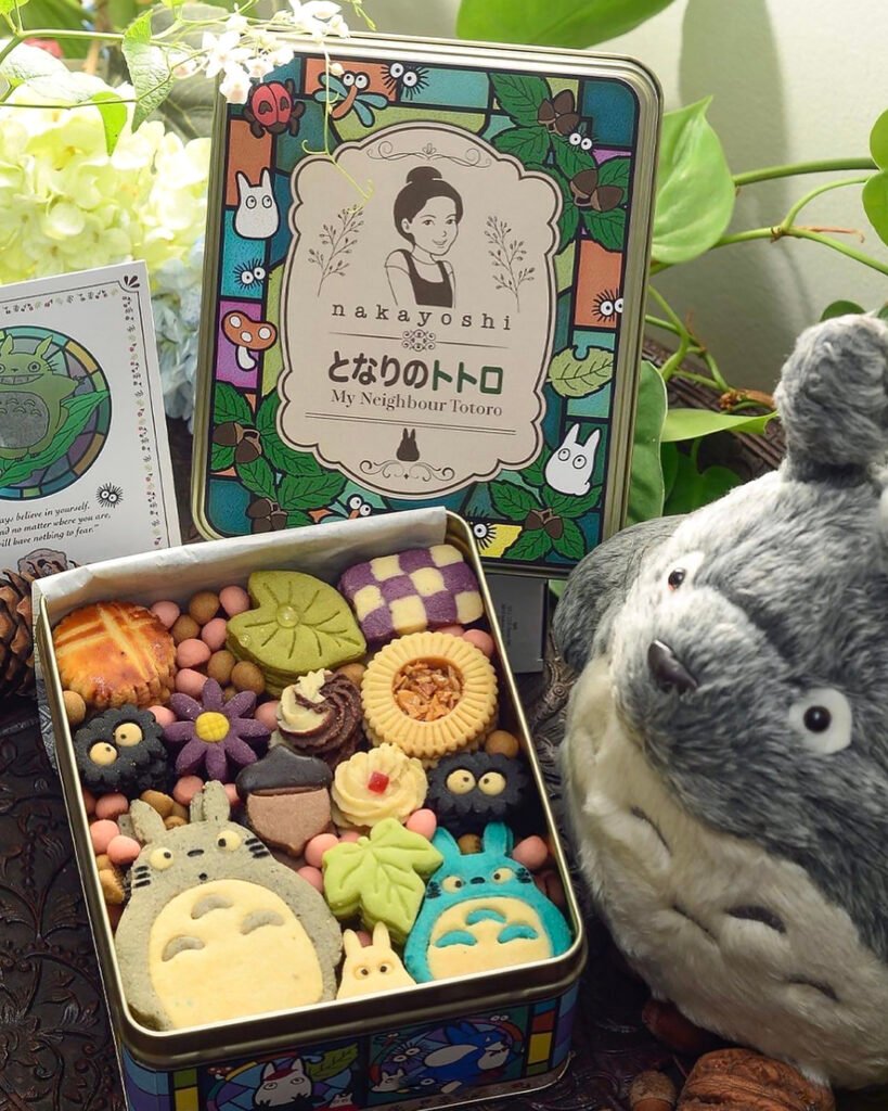 A box of adorable Totoro cookies of Nakayoshi Sweets in various shapes and sizes, with the Japanese characters for "My Neighbor Totoro" and inspiring quotes printed on the lid.