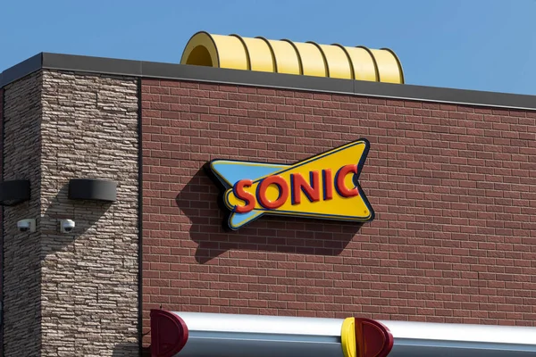 A Sonic Drive-In restaurant with a red brick exterior and a distinctive yellow and blue Sonic logo. The restaurant has a curved yellow roof and a partially visible red awning.